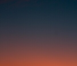 Crescent moon and fiery orange sunset horizon